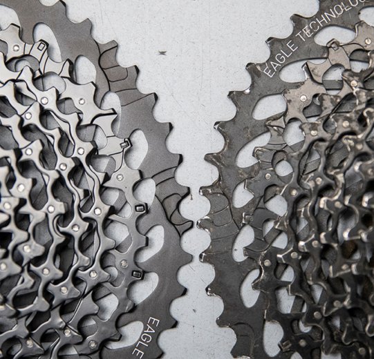 This image compares two SRAM cassettes. A new one is on the left, while an older one with clear signs of wear is on the right. 