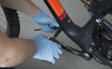 Die Plattformpedale eines Mountainbikes werden gelöst. 