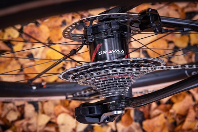 Detailfoto: Eine Gravaa-Nabe im Hinterrad eines Gravelbikes. Auf dem Boden liegt buntes Herbstlaub