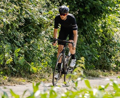 Rennradfahrer sprintet im Grünen