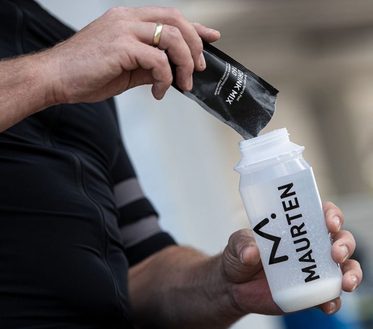 A man mixes a sports drink with a powder from Maurten.