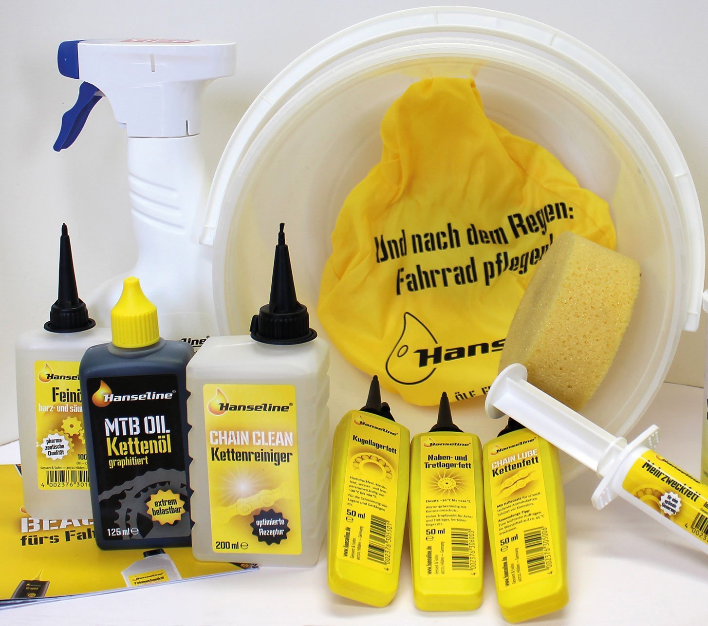Produits d’entretien vélo Hanseline avec huile, nettoyant et cire pour chaîne, graisse pour roulements et accessoires de nettoyage.