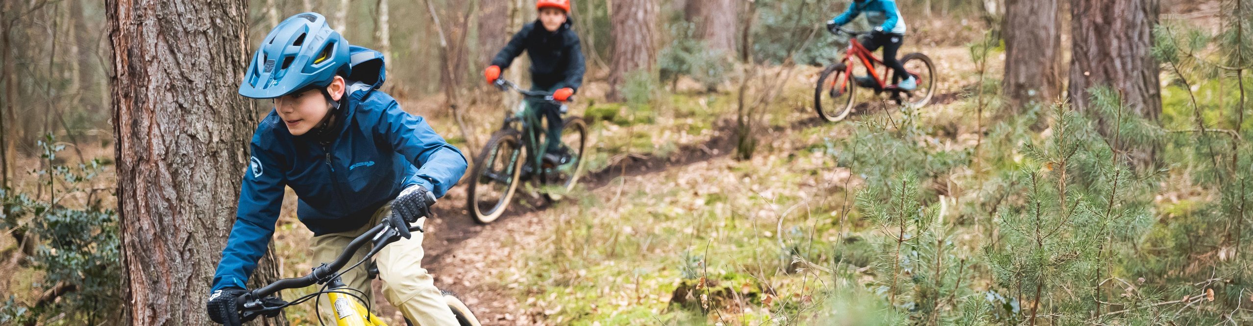 Kinder fahren mit SUPURB MTBs durch den Wald