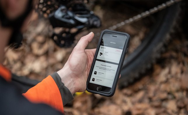 A cyclist configures his SRAM AXS shifting system with the help of his smartphone.