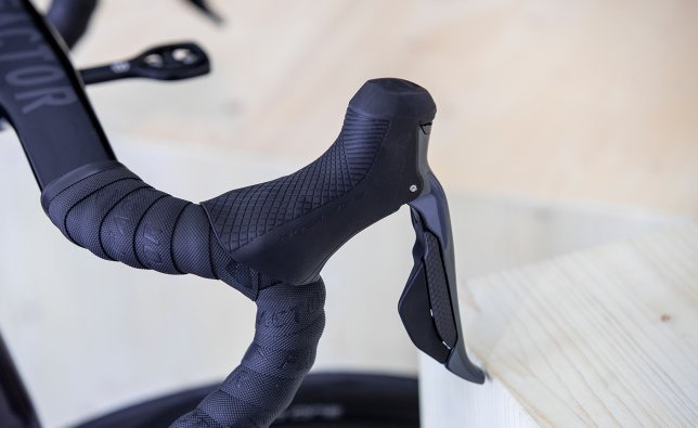 A Shimano Dura-Ace Di2 shift lever is mounted on a Factor One. No cable is visible on the cockpit.