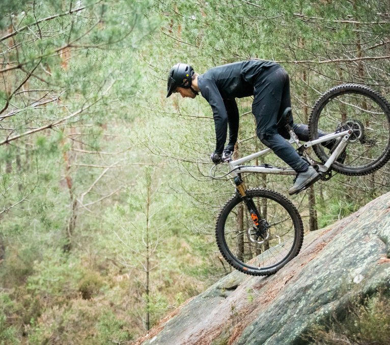 Christian aus dem bc Produktmanagement macht einen Stoppie auf einem Felsen.