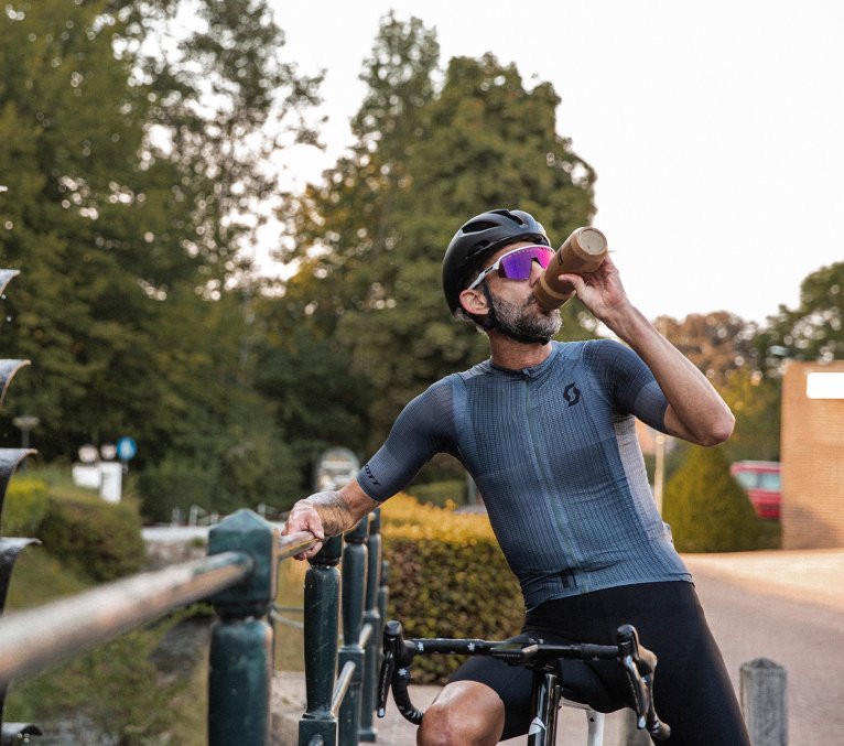 Rennradfahrer gönnt sich eine Pause und trinkt