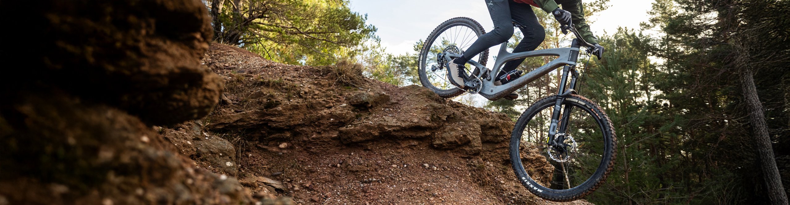 Ein Biker fährt auf einem bold Linkin 135 Pro Mountainbike durch den Wald