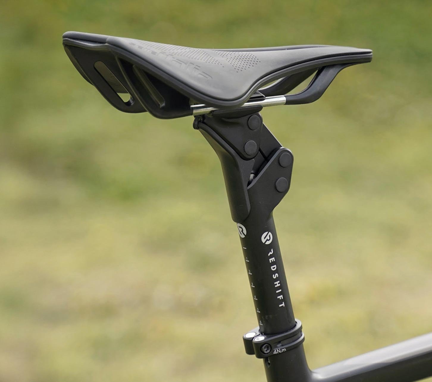 Nahaufnahme von Redshift Sattel und Sattelstütze an einem Gravelbike vor unscharfem Naturhintergrund