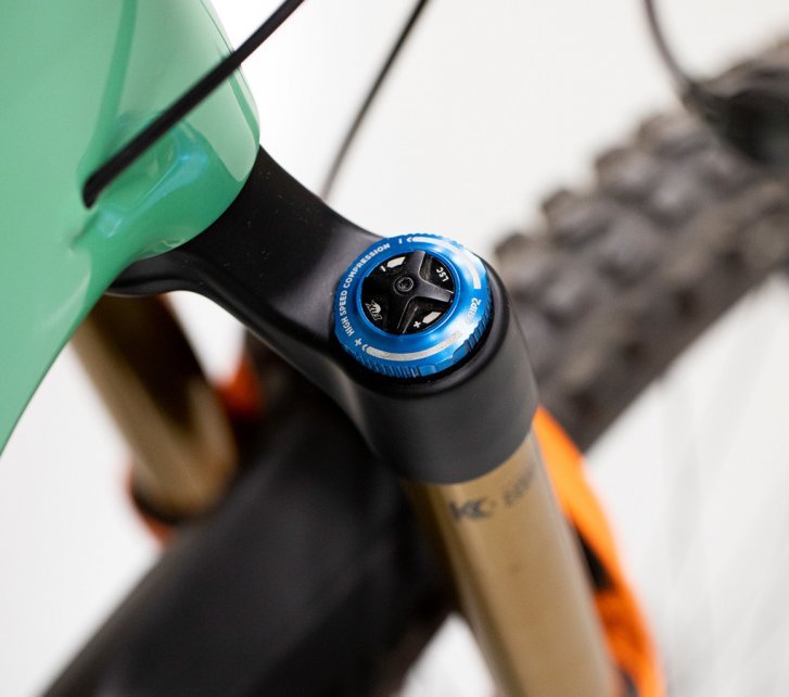 Pictured here is a Fox suspension fork. The focus of the image is on the top cap for setting the high-speed and low-speed compression.