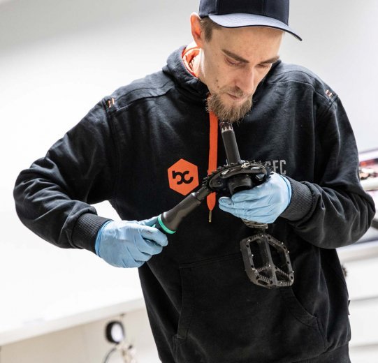 A mechanic tightens the chainring on the crank with a torque wrench.