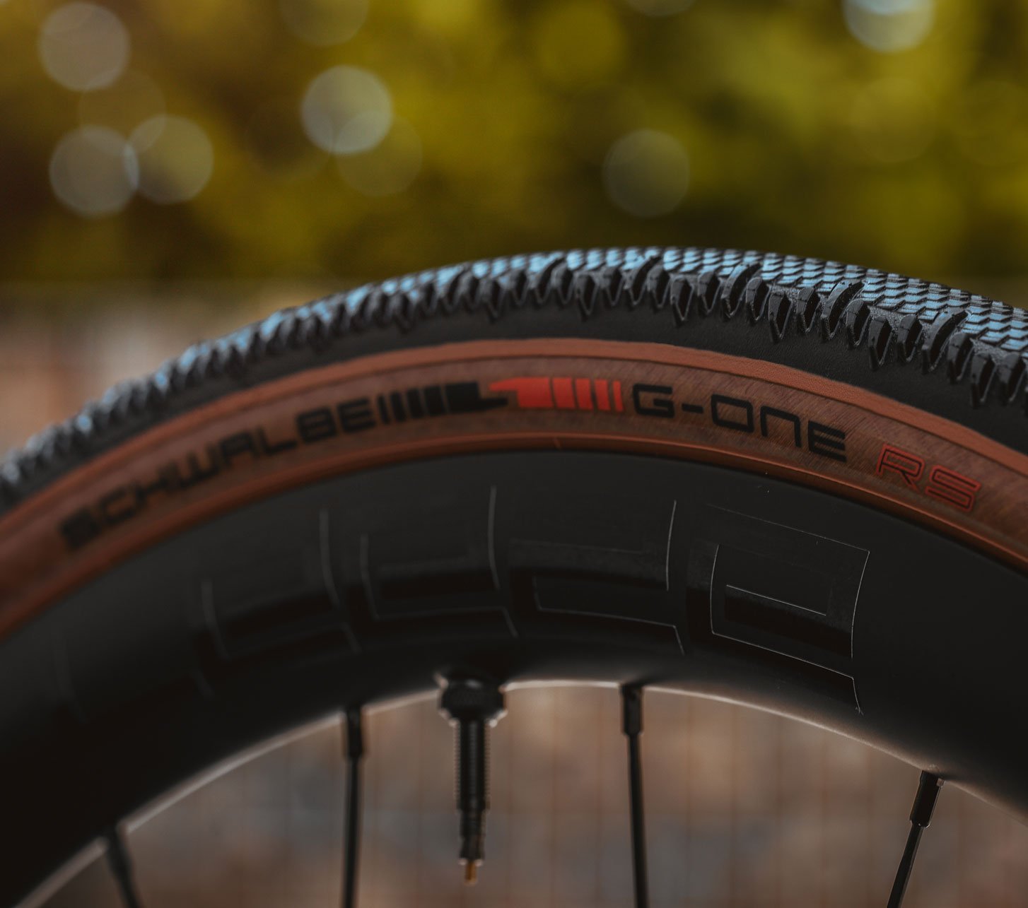 Primer plano del neumático gravel Schwalbe G-One RS con flanco marrón, banda de rodadura rápida y rueda de bicicleta para un alto rendimiento en gravel.
