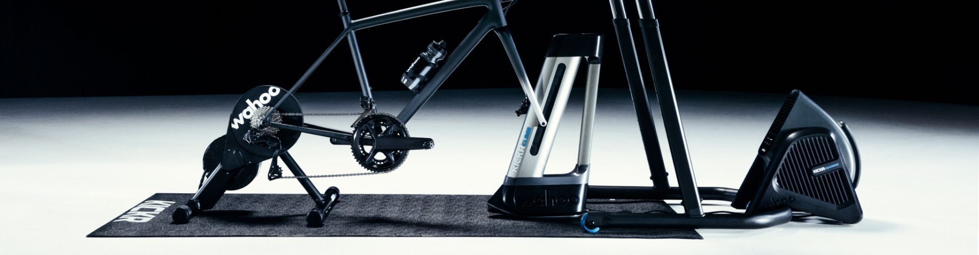 Es ist ein Wahoo Indoortraining Set -up bestehend aus dem Wahoo KICKR CORE, dem CLIMB und dem HEADWIND Ventilator zu sehen. Das Foto ist in einem dunklen Studiosetup fotografiert.