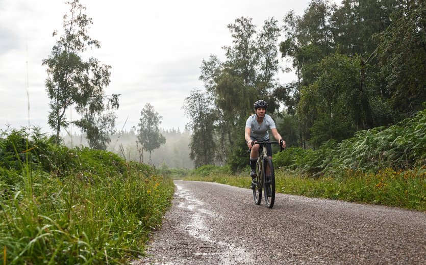 Un ciclista de Gravel montando por un camino de gravilla.