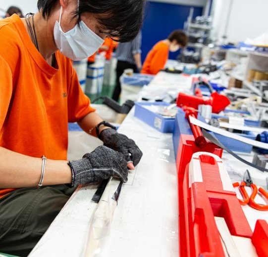 Un employé de production assemble la fourche à partir de plusieurs découpes de carbone.