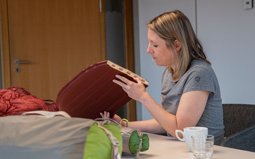 bc-Brandmanagerin Svenja betrachtet den Querschnitt einer selbstaufblasenden Isomatte.