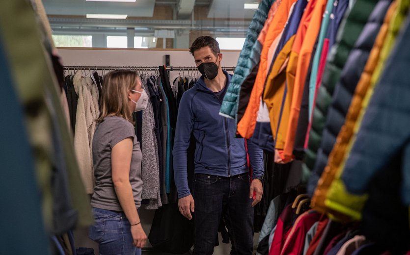 bc-Brandmanagerin Svenja und Vaude-Produktmanager Markus stehen stehen vor einem Schrank mit bunten Jacken.