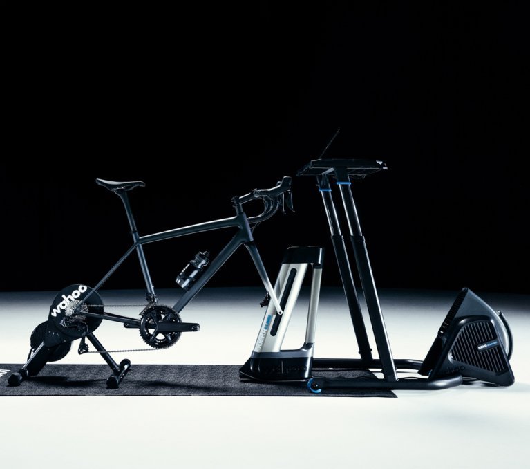 Es ist ein Wahoo Indoortraining Set -up bestehend aus dem Wahoo KICKR CORE, dem CLIMB und dem HEADWIND Ventilator zu sehen. Das Foto ist in einem dunklen Studiosetup fotografiert.