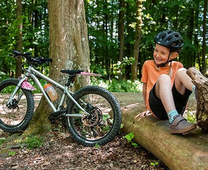 Early Rider Pause auf Baumstamm