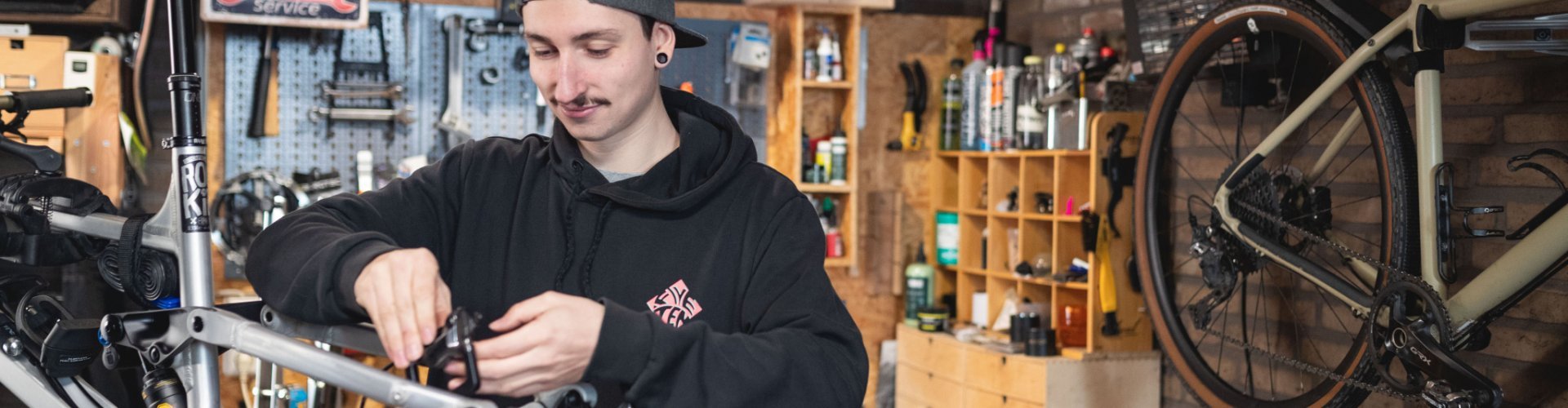 bc Mechanic Pascal checks the rear brake of a RAAW mountain bike in an at-home workshop.