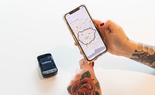 Eine auf Komoot geplante Route wird von einem Smartphone auf einen Wahoo ELEMNT Bolt 2.0 übertragen.