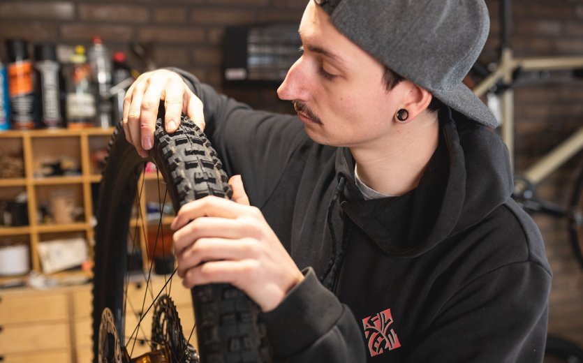 bc Mechanic Pascal checks a tyre for cracks and damage. 