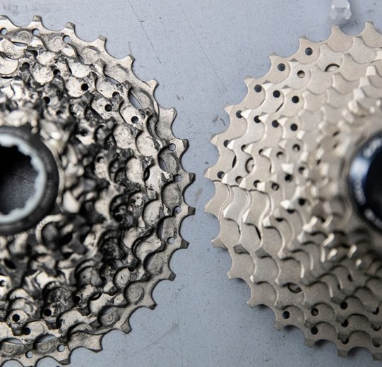 Vergleichsbild zweier Shimano-Kassetten. Rechts eine neue, auf der linken Seite des Bildes eine mit deutlich Abnutzungsspuren.