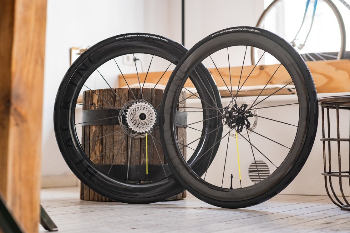 Zwei Black Inc Carbonlaufräder für Rennräder lehnen in einem hellen, gemütlichen Showroom
