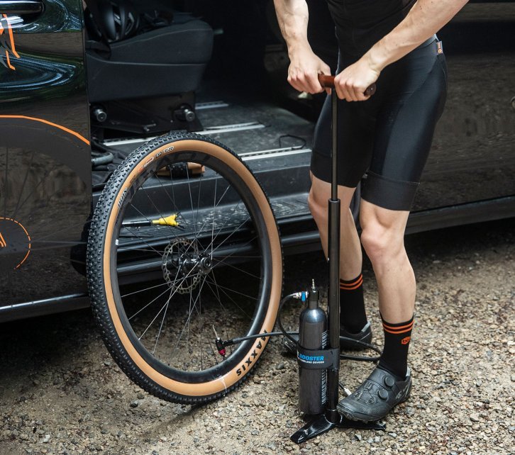 Un pneu tubeless de Maxxis est gonflé à l'aide d'une pompe booster.