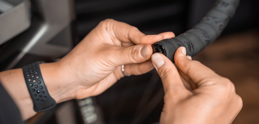 Die Mechanikerin drückt den Lenkerstopfen in den Lenker. 