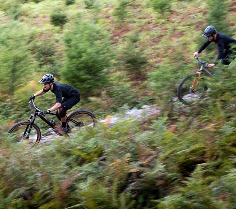 Georg et Chris de l’équipe de bc dévalent une pente sur leurs vélos bc original Podsol.