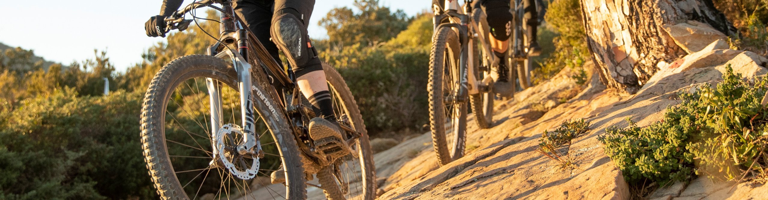 3 Mountainbiker in der Sonne auf felsigem Terrain