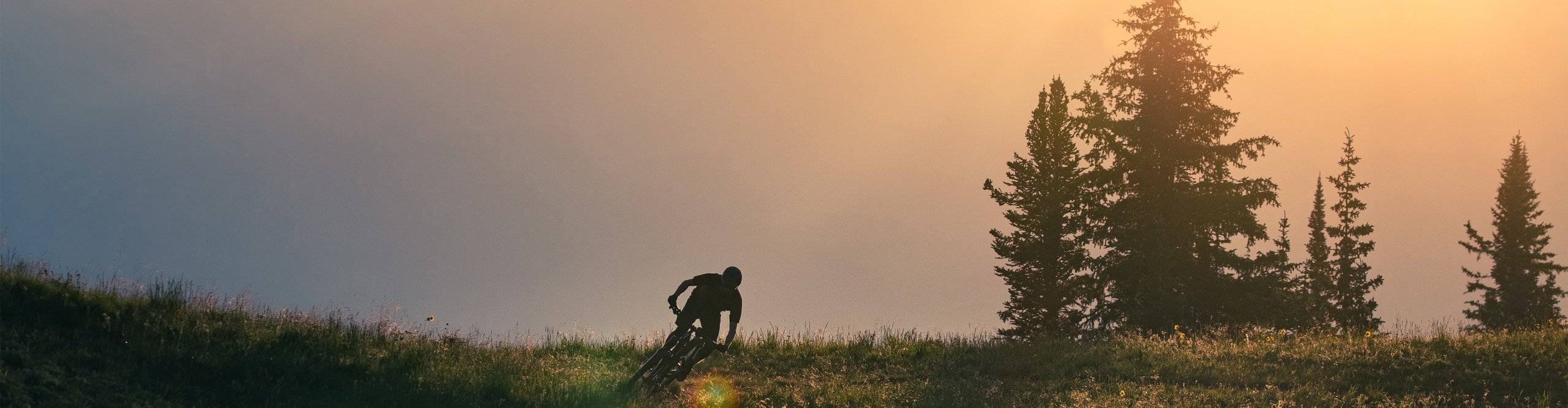 Mountainbiker lehnt sich bei Sonnenuntergang in die Kurve