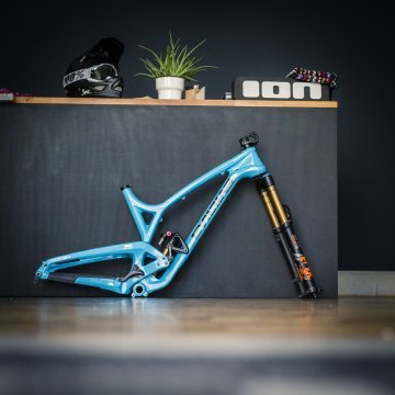 hellblauer EVIL Bikes Rahmen steht, bestückt mit einer Federgabel, vor einer grauen Tresenwand