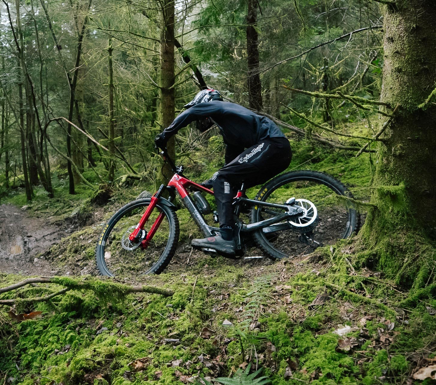 Mountain biker rides a Dreadnought e-mountain bike on a technical forest trail.