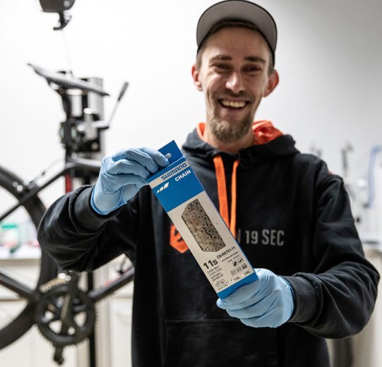 bc Mechanic Thomas holds a new Shimano 11s chain up to the camera. 