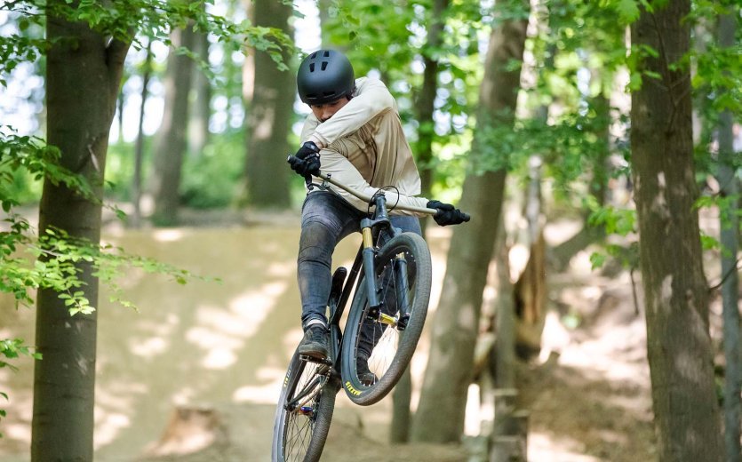 A biker does an X-UP on his dirtbike. 