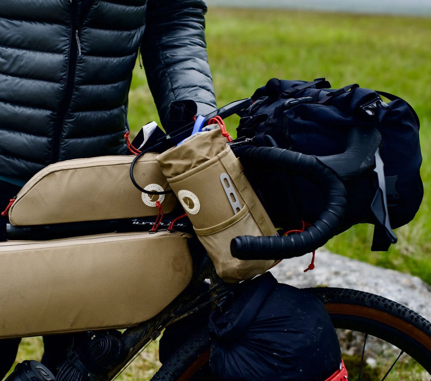 Équipement de bikepacking avec sacoches vélo Fjällräven jaunes sur le cintre et le tube supérieur d’un gravel Specialized