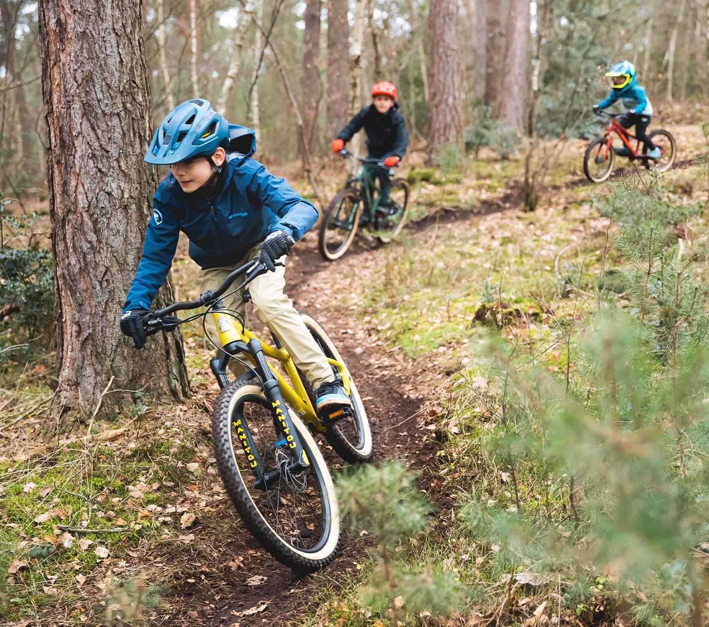 Kinder fahren mit SUPURB MTBs durch den Wald