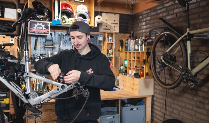 Le mécanicien de bc Pascal vérifie le frein arrière d'un VTT RAAW dans un atelier de bricolage.