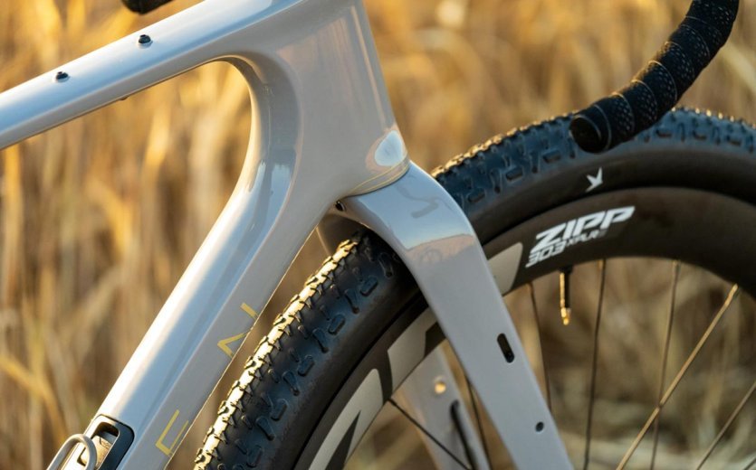 Detail view of the fork, tire clearance and Zipp wheel on the OPEN WI.DE gravel bike in evening light.