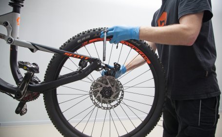 The bc mechanic removes the axle and loosens the rear wheel. 