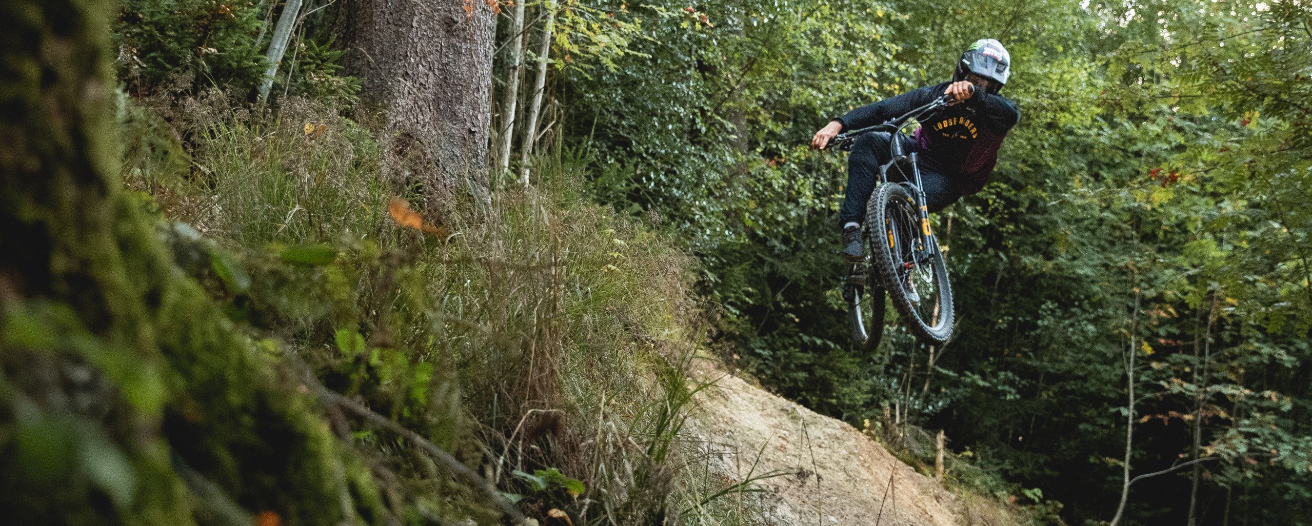 Gravity MTB Fahrer springt in die Höhe