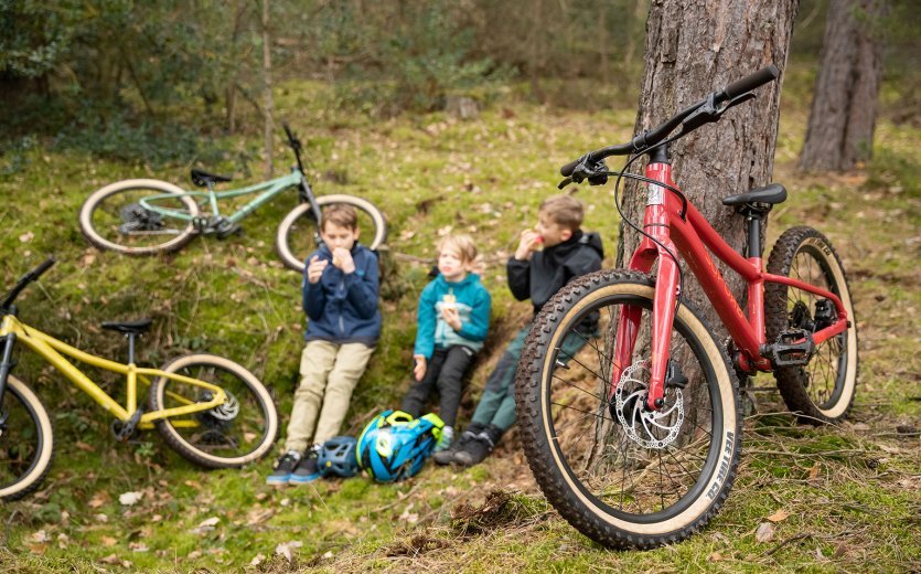 Mehrere Kinder machen Pause und ihre SUPURB MTBs stehen im Hintergrund