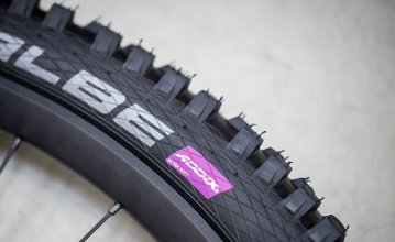 La photo montre une partie d'un pneu VTT de Schwalbe avec le composé de caoutchouc ADDIX Ultra Soft.