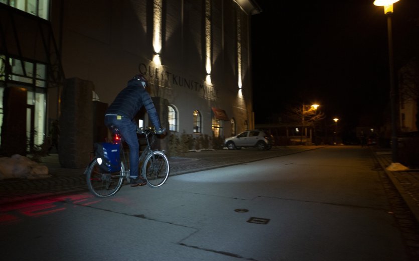 Radfahrer in dunkler Kleidung bei Nacht. Schlecht sichtbar.