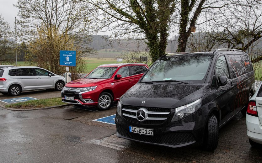 Der schwarze bc-Firmenwagen steht abfahrbereit auf einem Parkplatz.