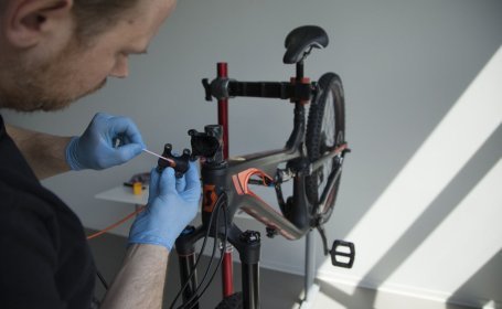 Assembly paste is being applied to the stem front plate using a cotton swab.