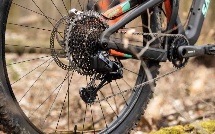 Pictured is a Santa Cruz full-suspension bike equipped with an electronic SRAM X01 EAGLE AXS in the forest.