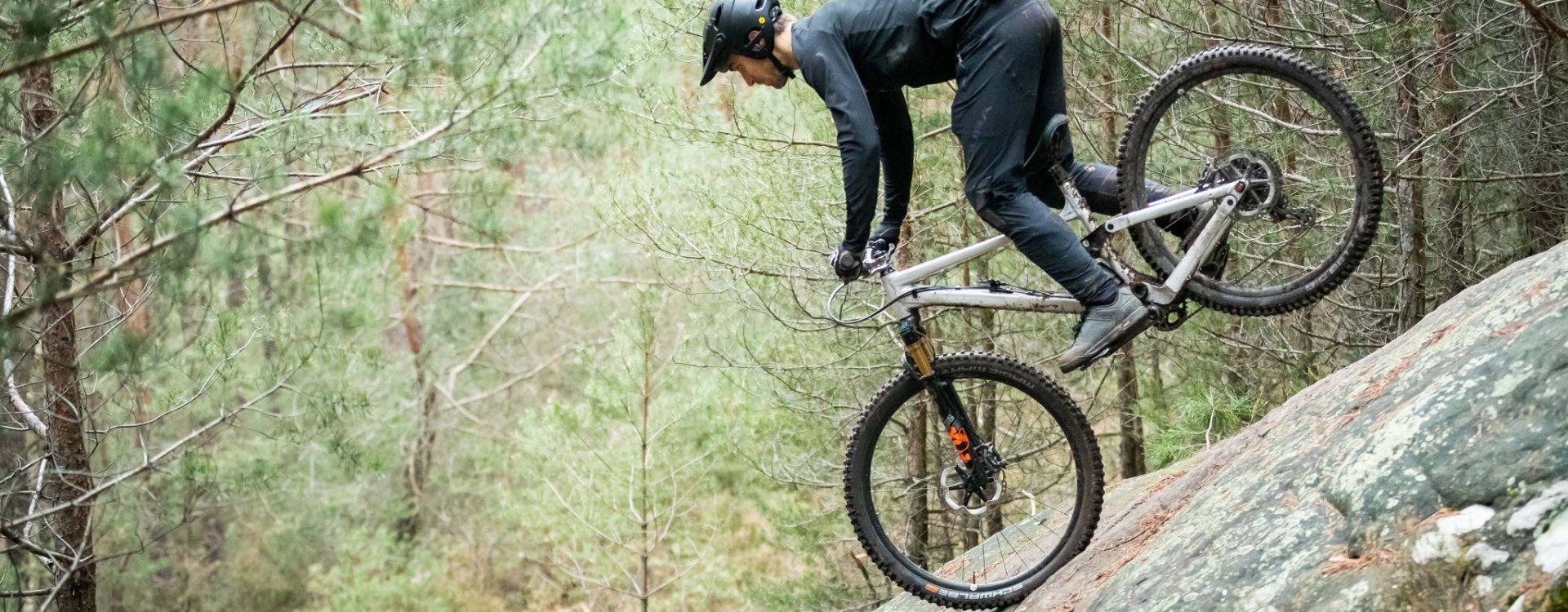 Christian aus dem bc Produktmanagement macht einen Stoppie auf einem Felsen.